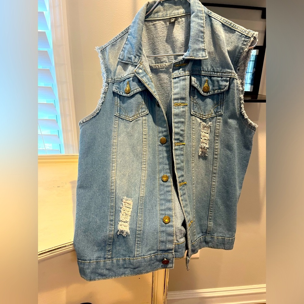 Women’s distressed jean vest. No size on tag but I believe it is a size medium